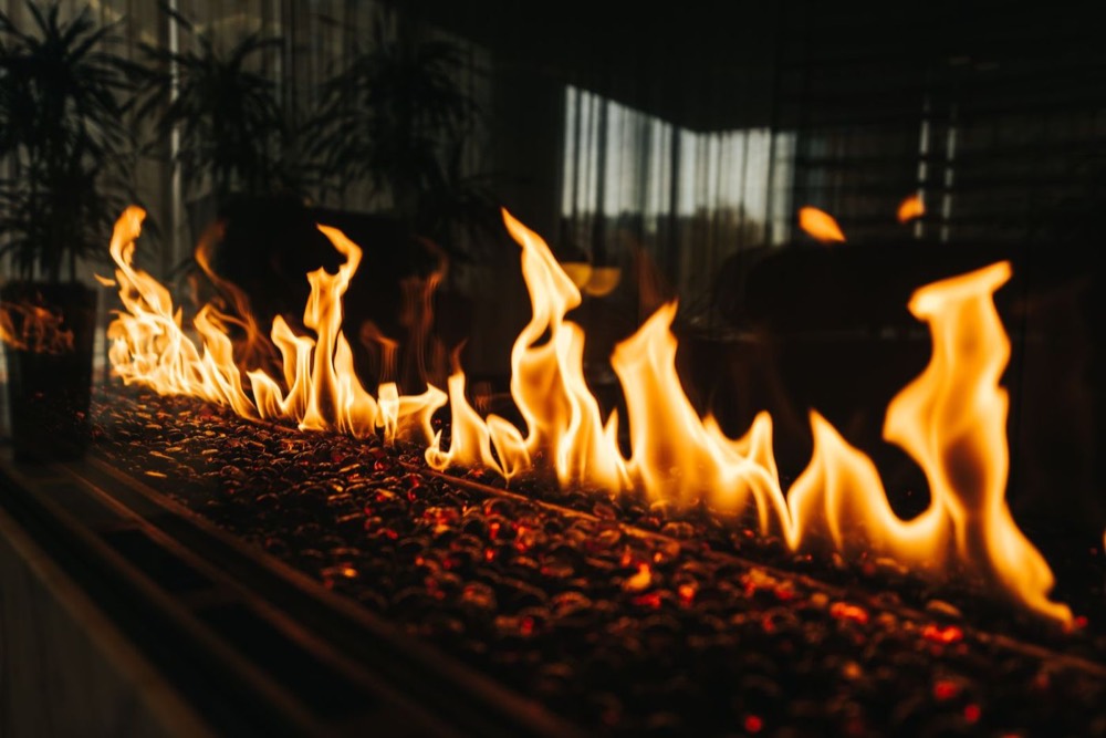 Gas log set alight inside a fireplace — Your Local Chimney Team · Pompano Beach, FL
