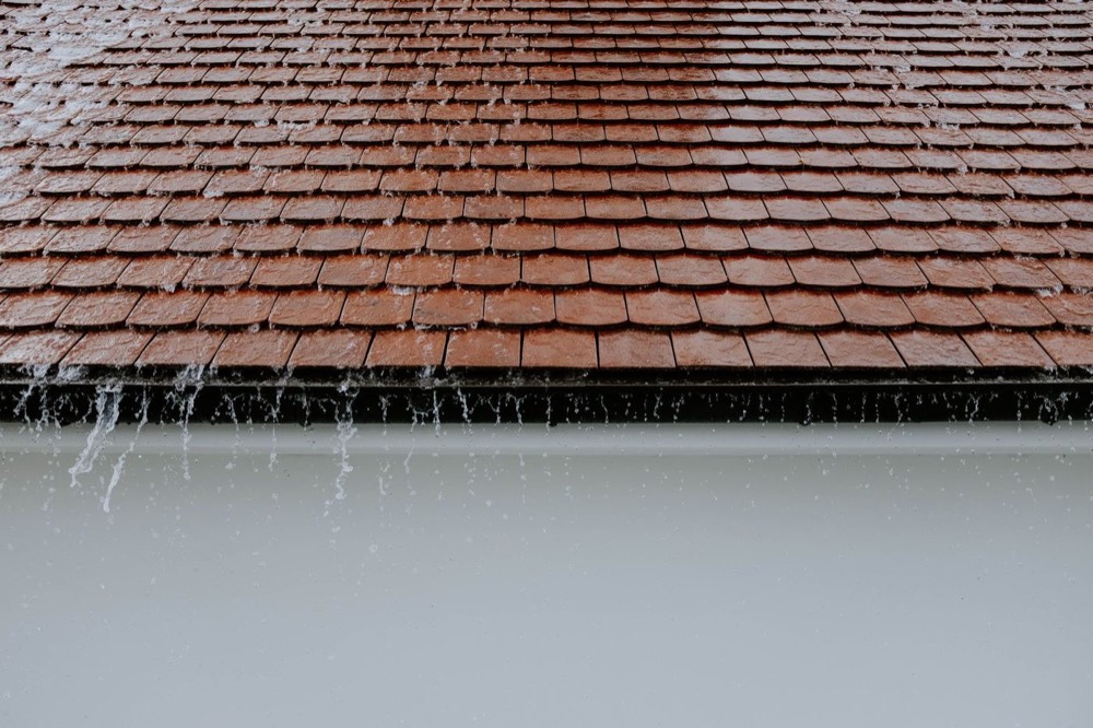 Rain running off a roof near a chimney — Pompano Beach, FL