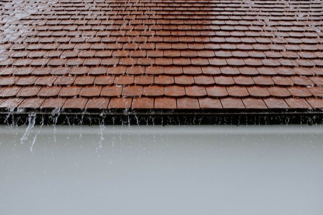 Rain running off a roof near a chimney — Chase Cover Replacement in Pompano Beach, FL